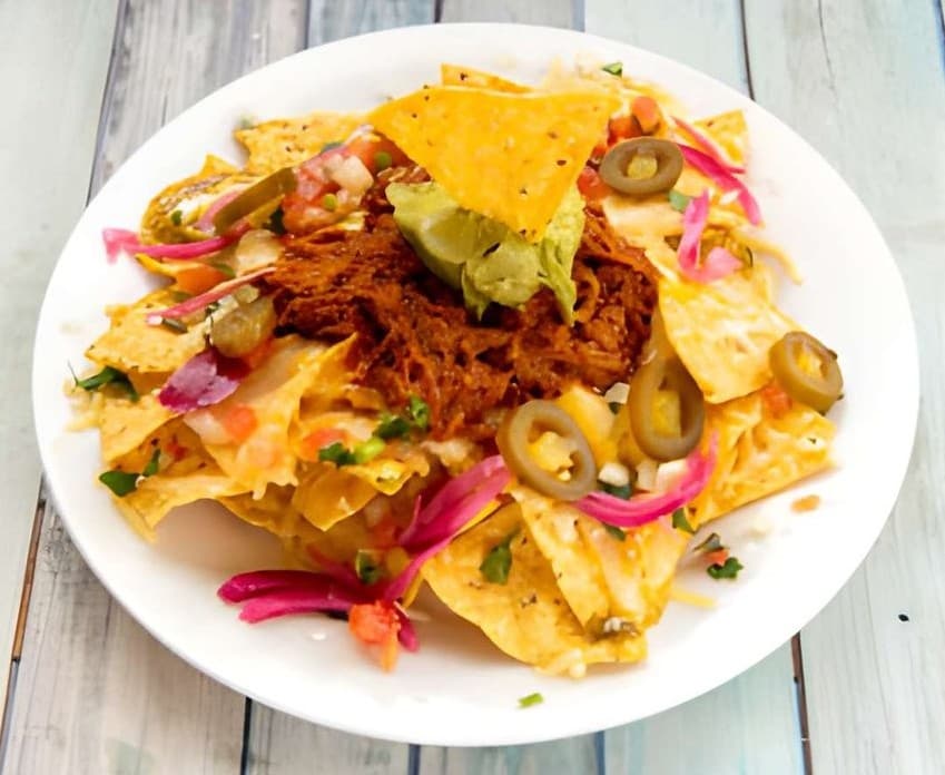 Nachos con cheddar, cochinita pibil y guacamole